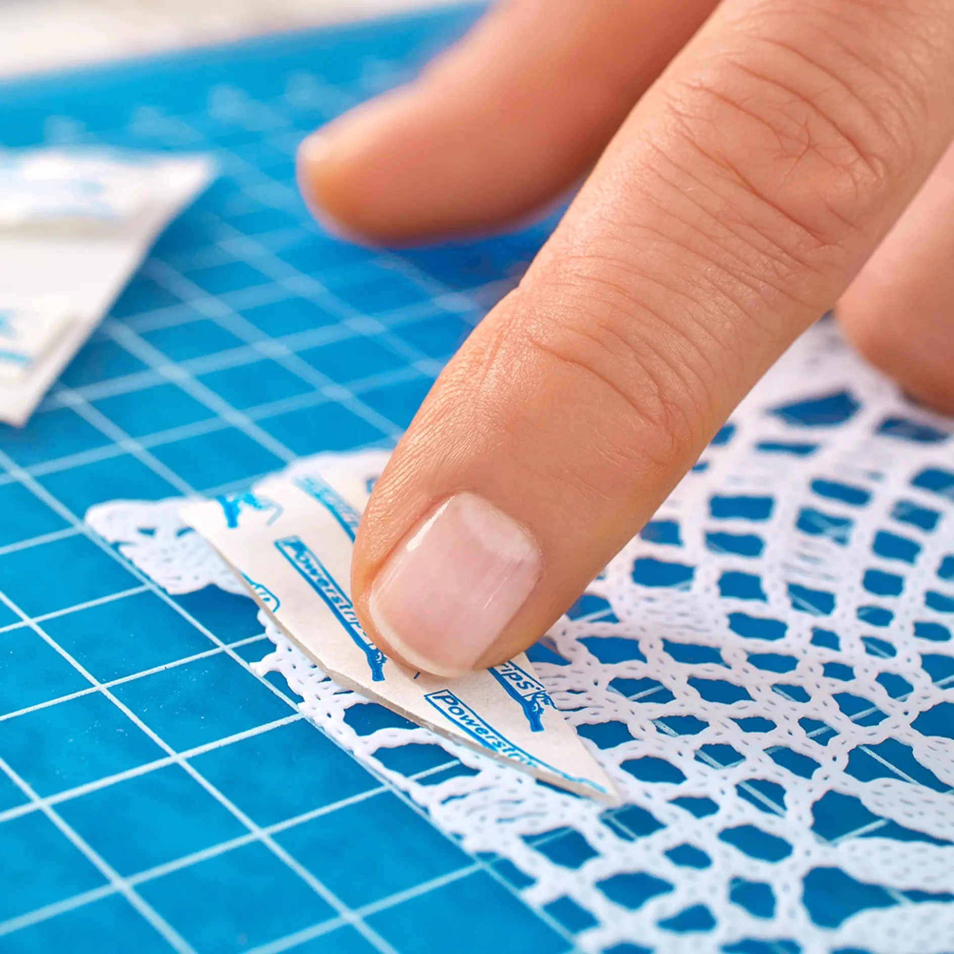 Applying adhesive strips for transparent & glass 0.2kg while making a lace window treatment.