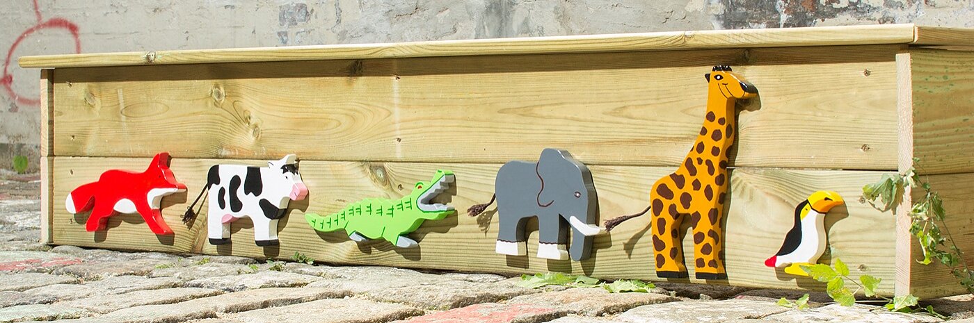 Several wooden animals applied to sandbox.