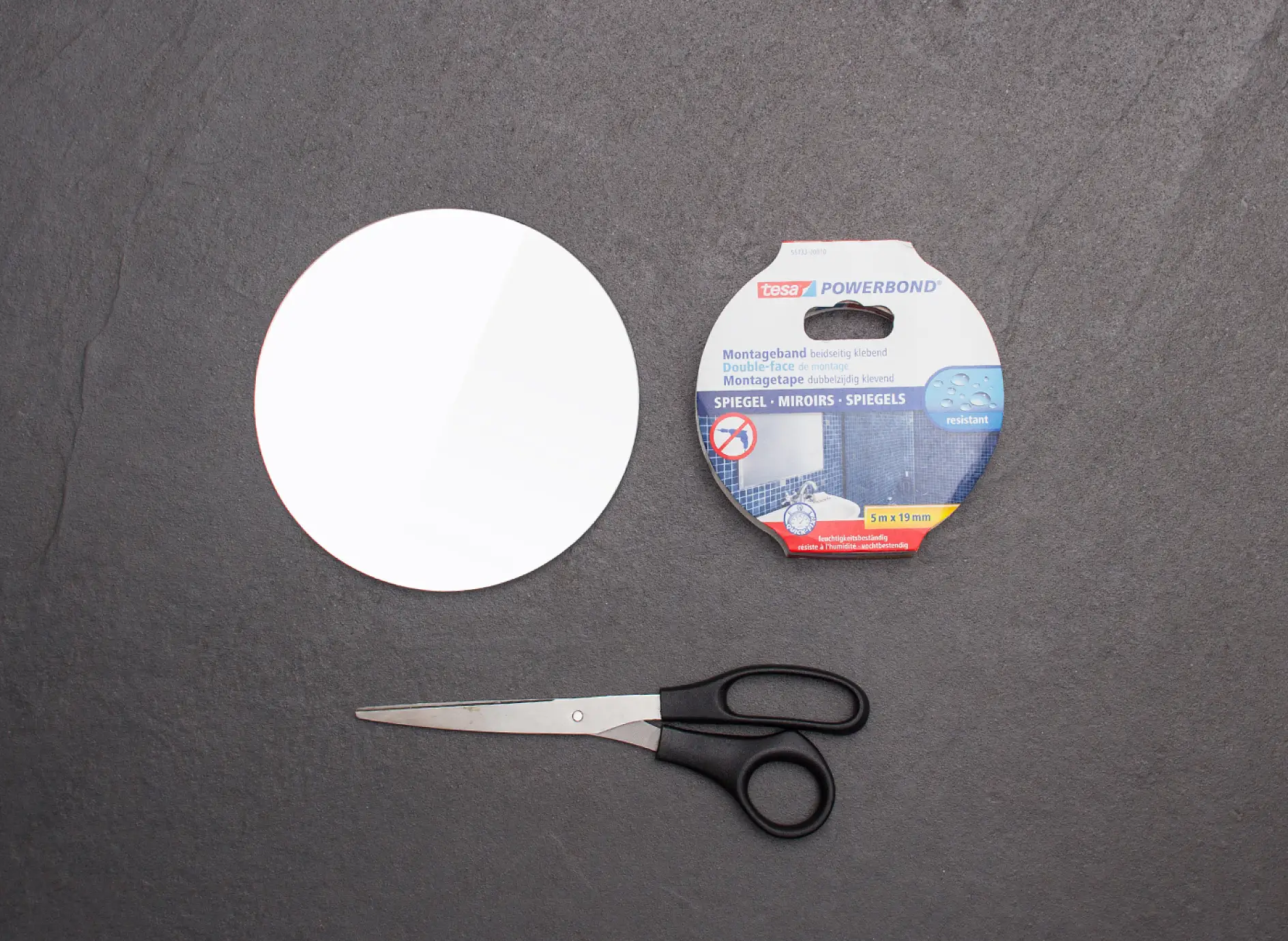 Scissors, small make-up mirror and tesa Powerbond® MIRROR adhesive tape.