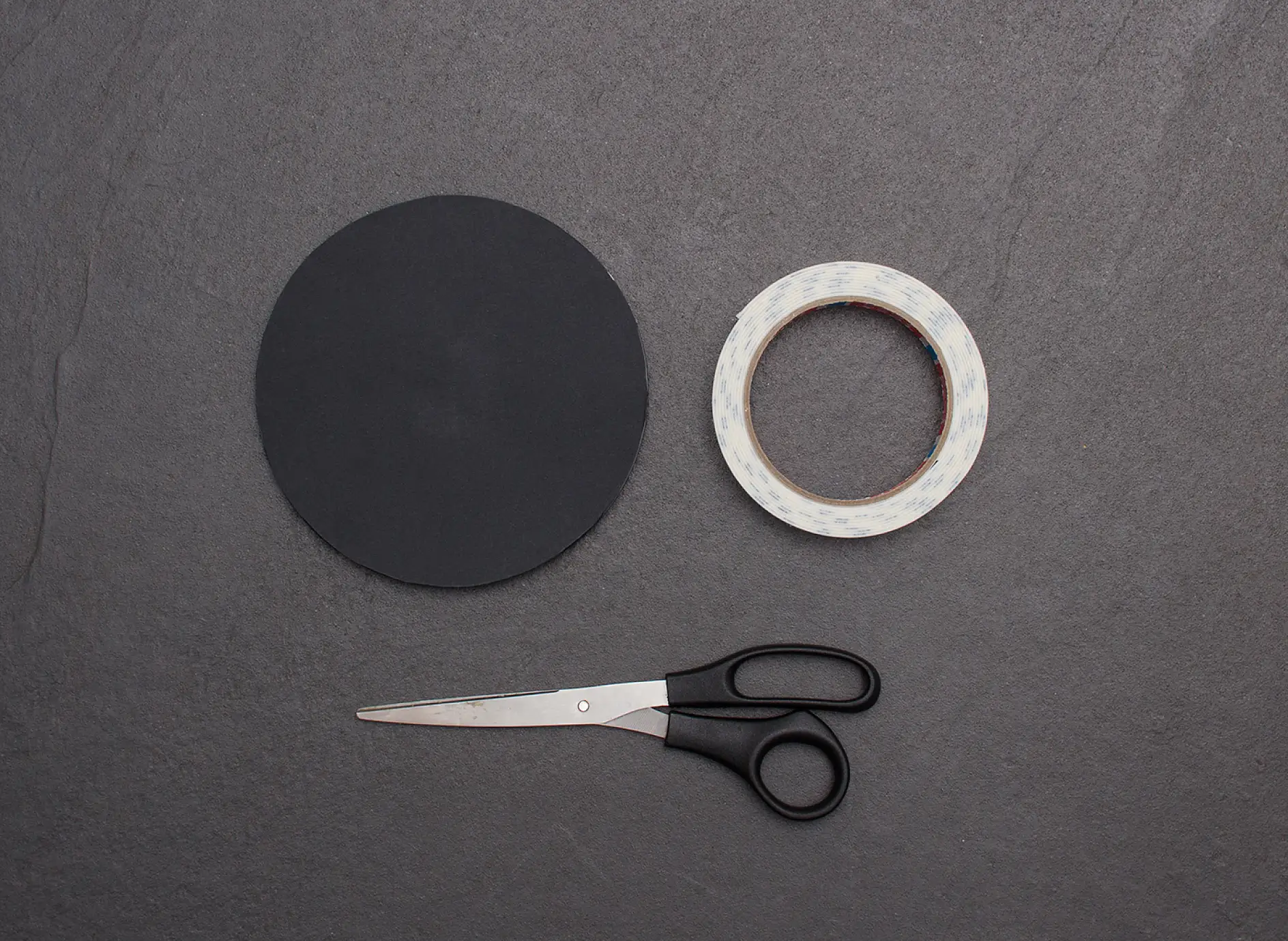 Scissors, reverse of small make-up mirror and tesa Powerbond® MIRROR adhesive tape.