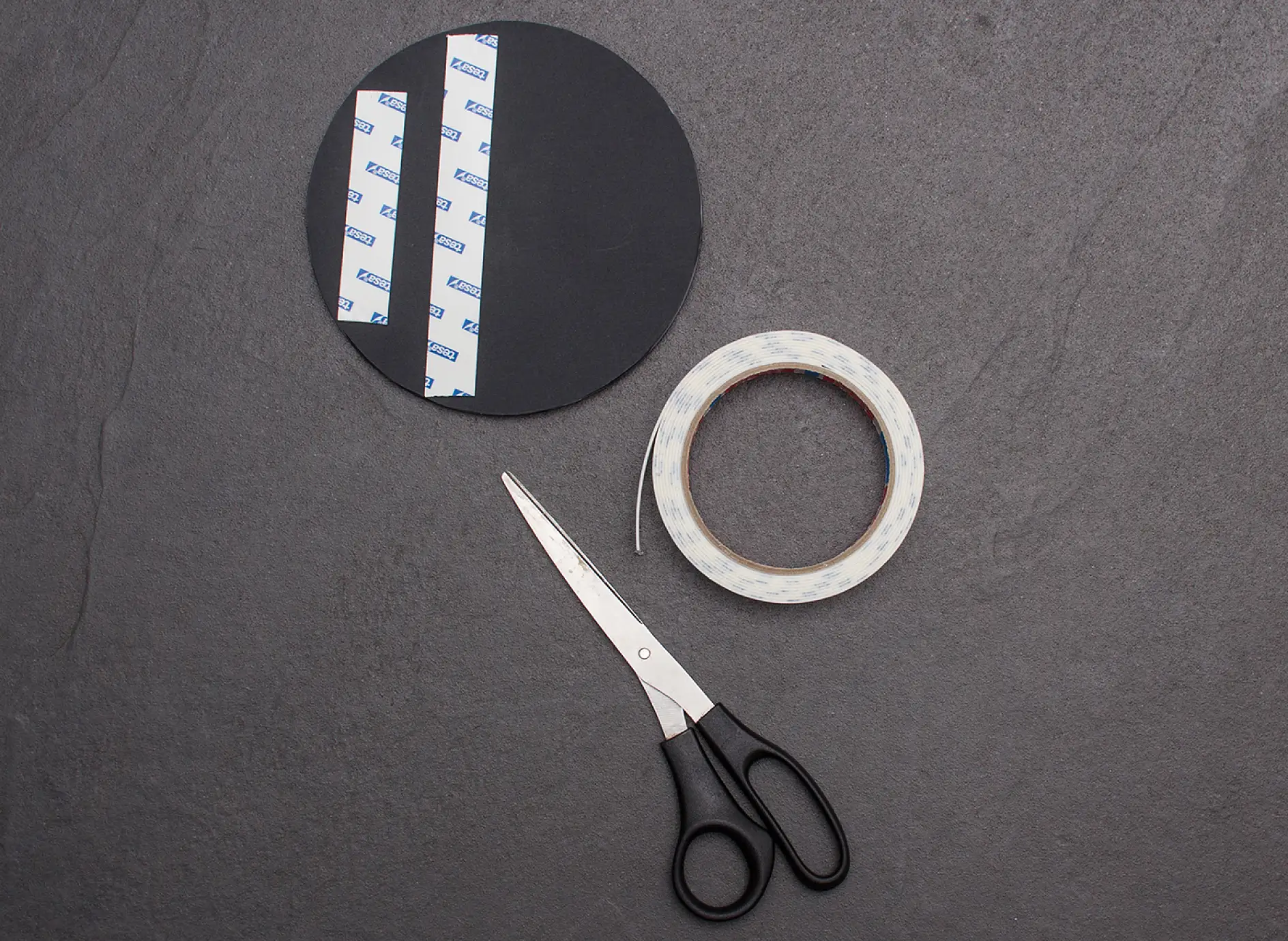 Scissors and two strips of tesa Powerbond® MIRROR adhesive tape applied to reverse of mirror.