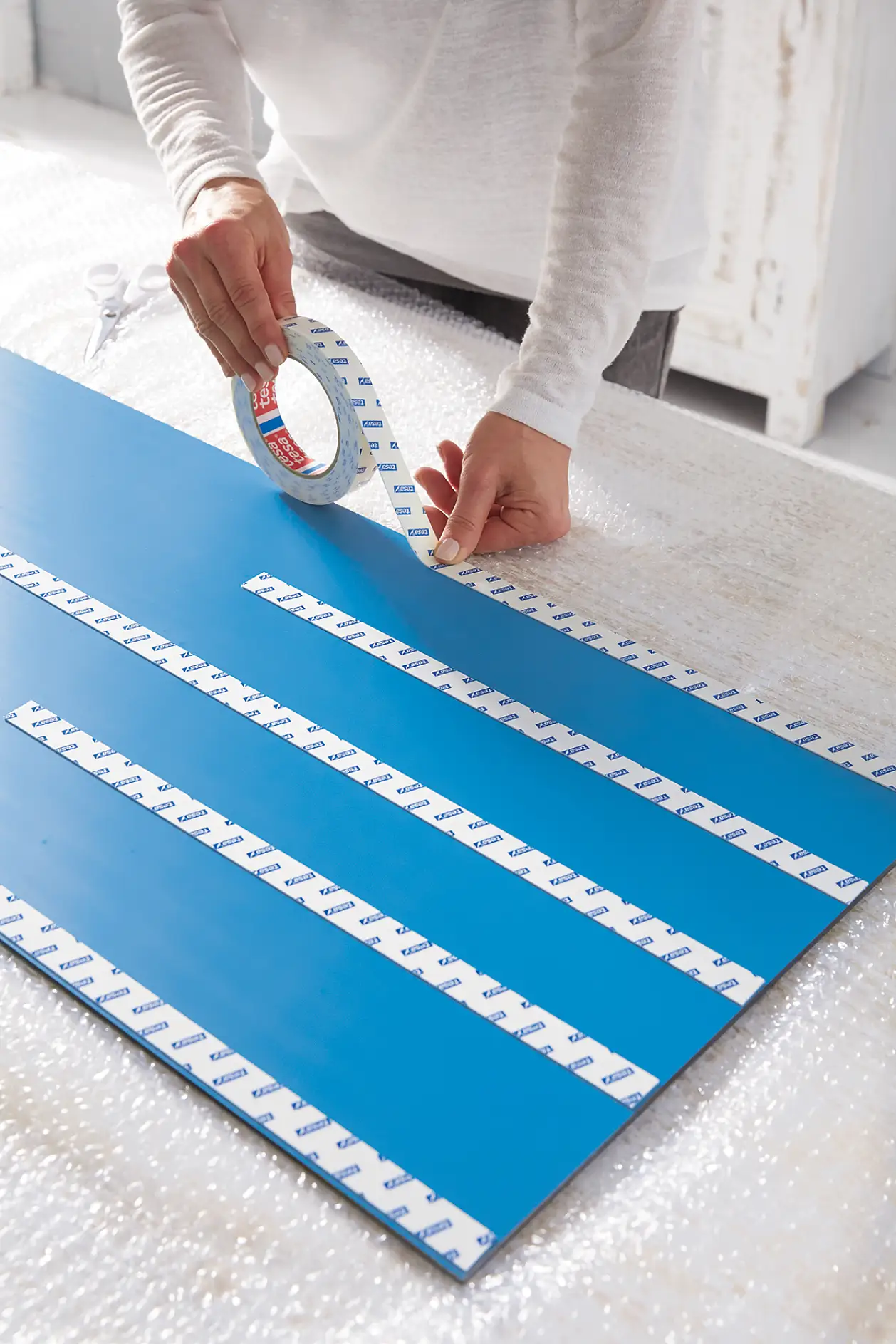 Evenly apply Powerbond® in vertical strips – alternately full length and 40 cm length – on the back of the mirror and press five seconds.