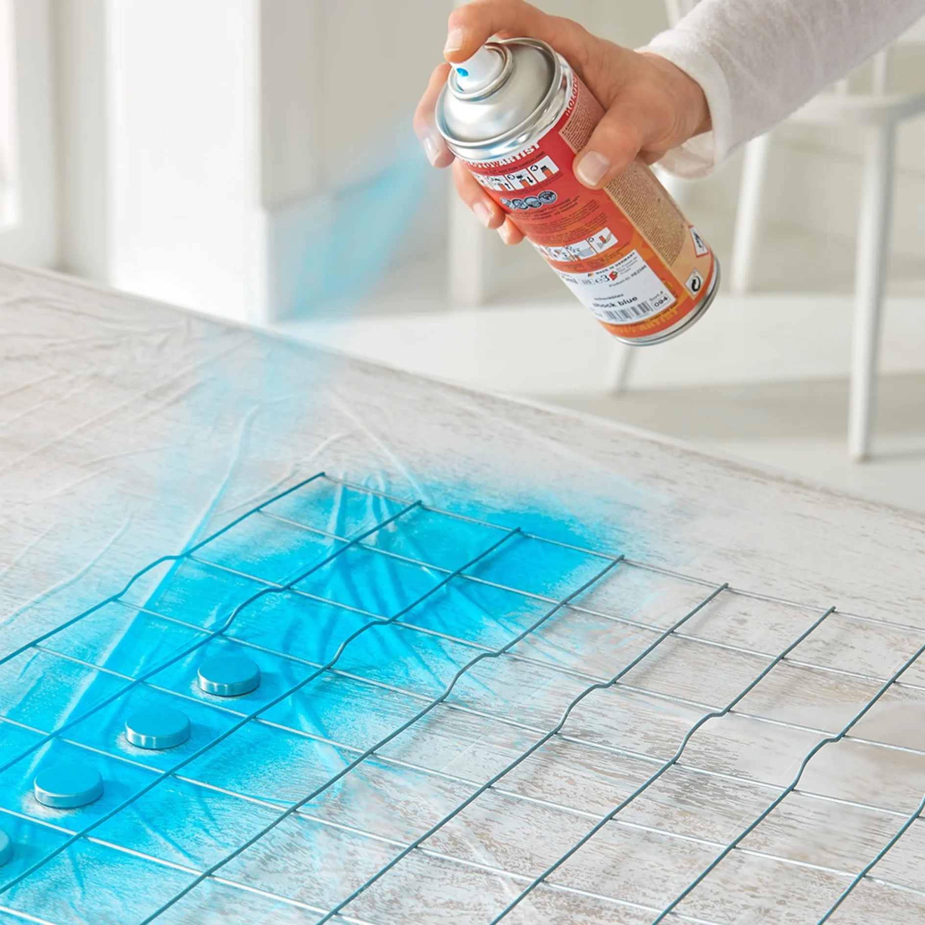 Usinga drop cloth while making an iron mesh board office organiser.