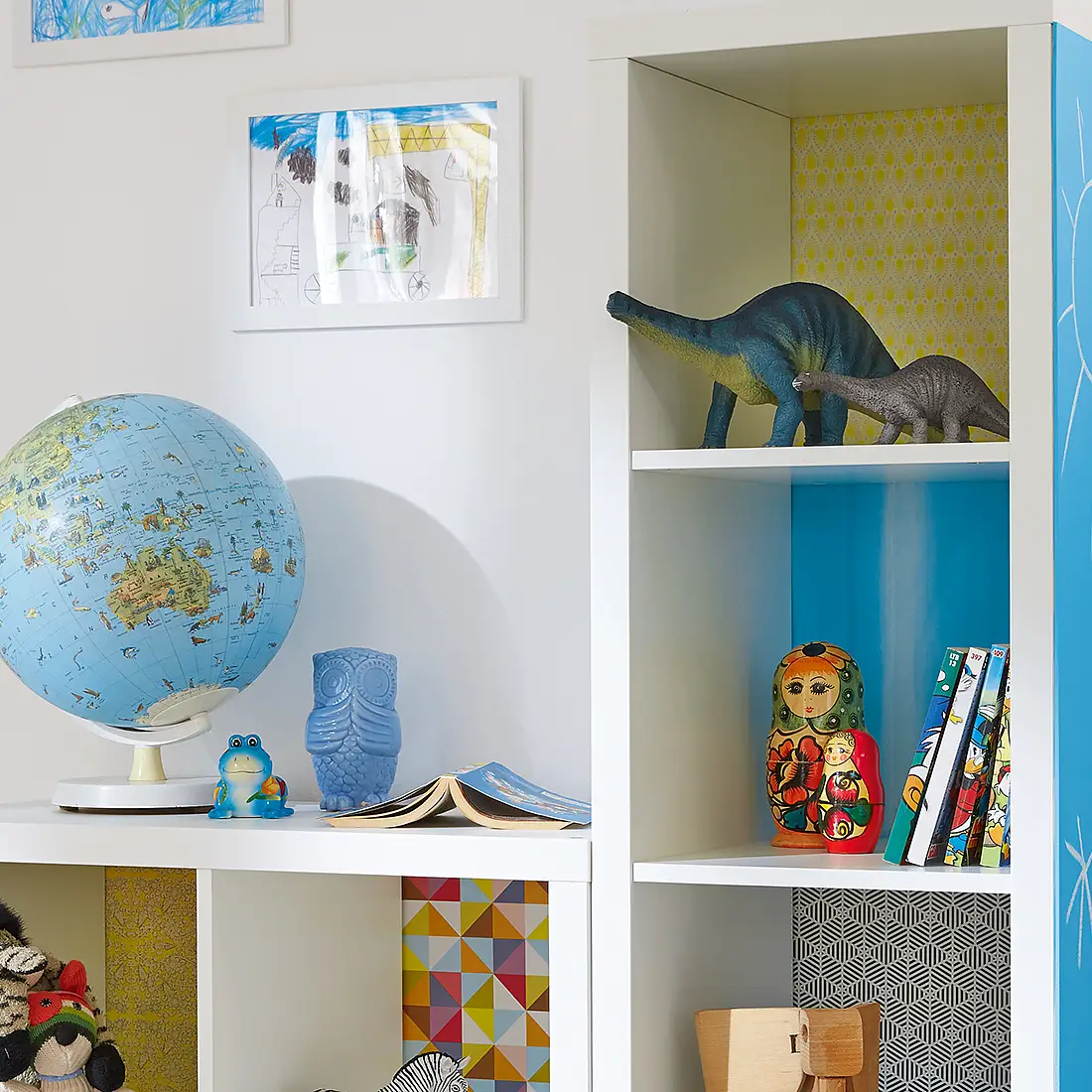 Here's an idea that kids will love. Each shelf has its own background, using decorative paper, stuck with tesa® Spray Glue PERMANENT, and on the side of the unit, there's a big blackboard so they're free to write or paint.