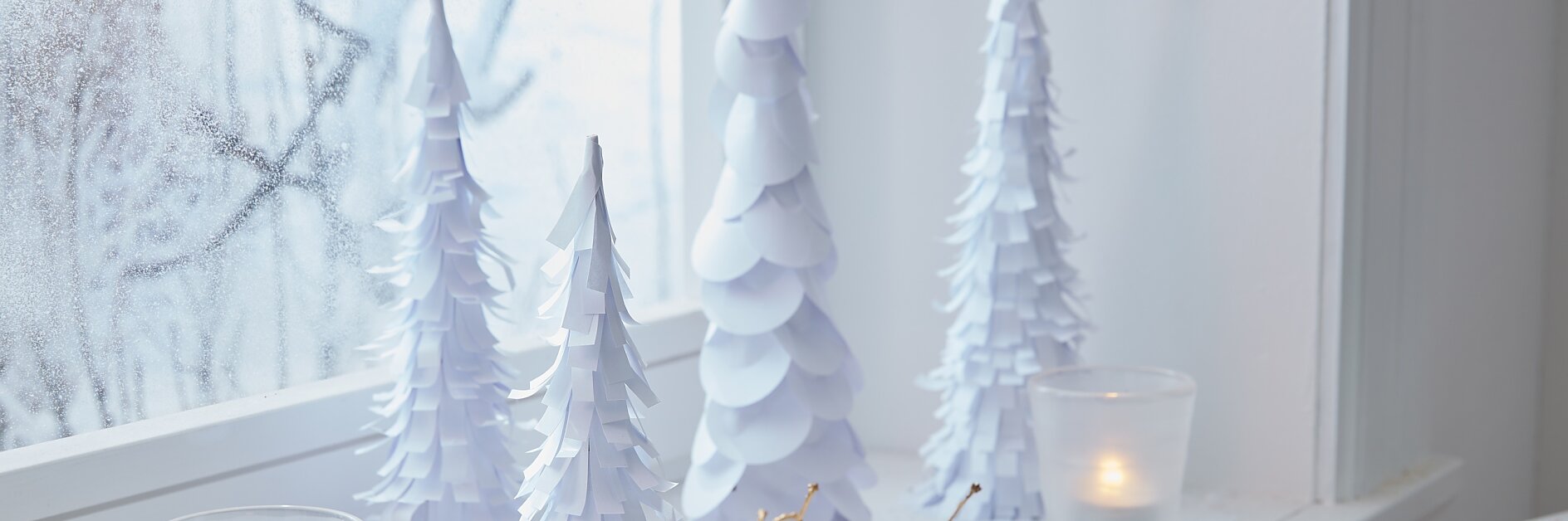 Many white paper trees on the windowsill bring the winter wonderland into your house, even if it's not snowing outside.