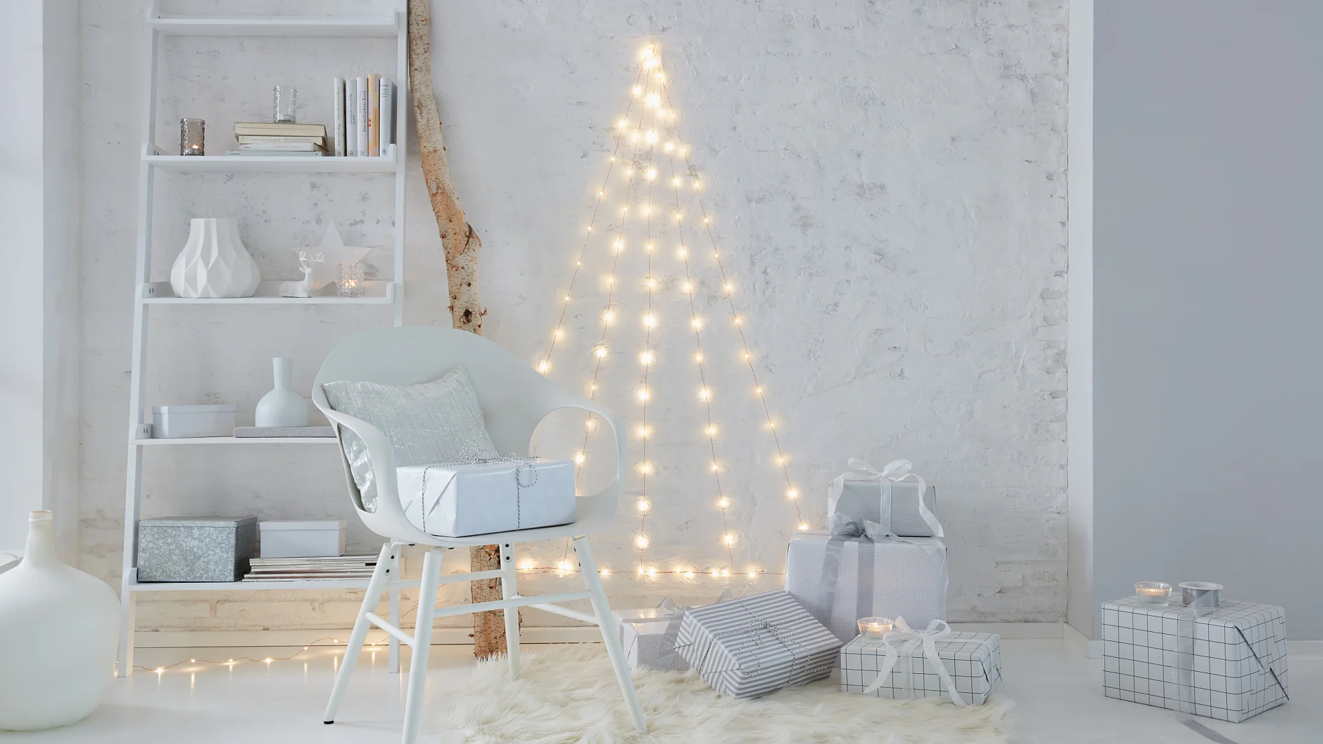 Needleless and extremely low-maintenance: A Christmas tree that doesn't need decorations. Create the tree with LED fairy lights that are fixed to the wall with transparent hooks.