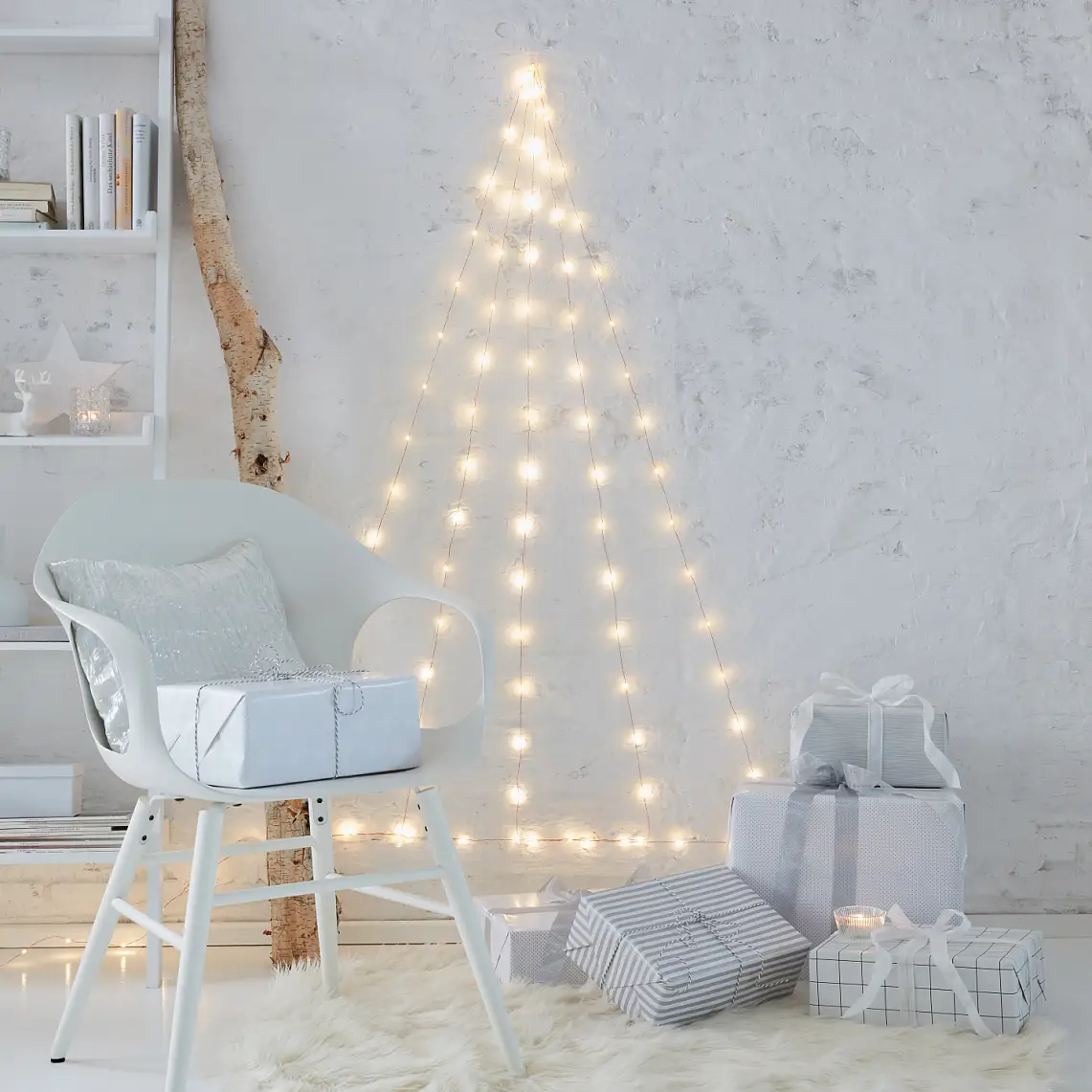 Needleless and extremely low-maintenance: A Christmas tree that doesn't need decorations. Create the tree with LED fairy lights that are fixed to the wall with transparent hooks.