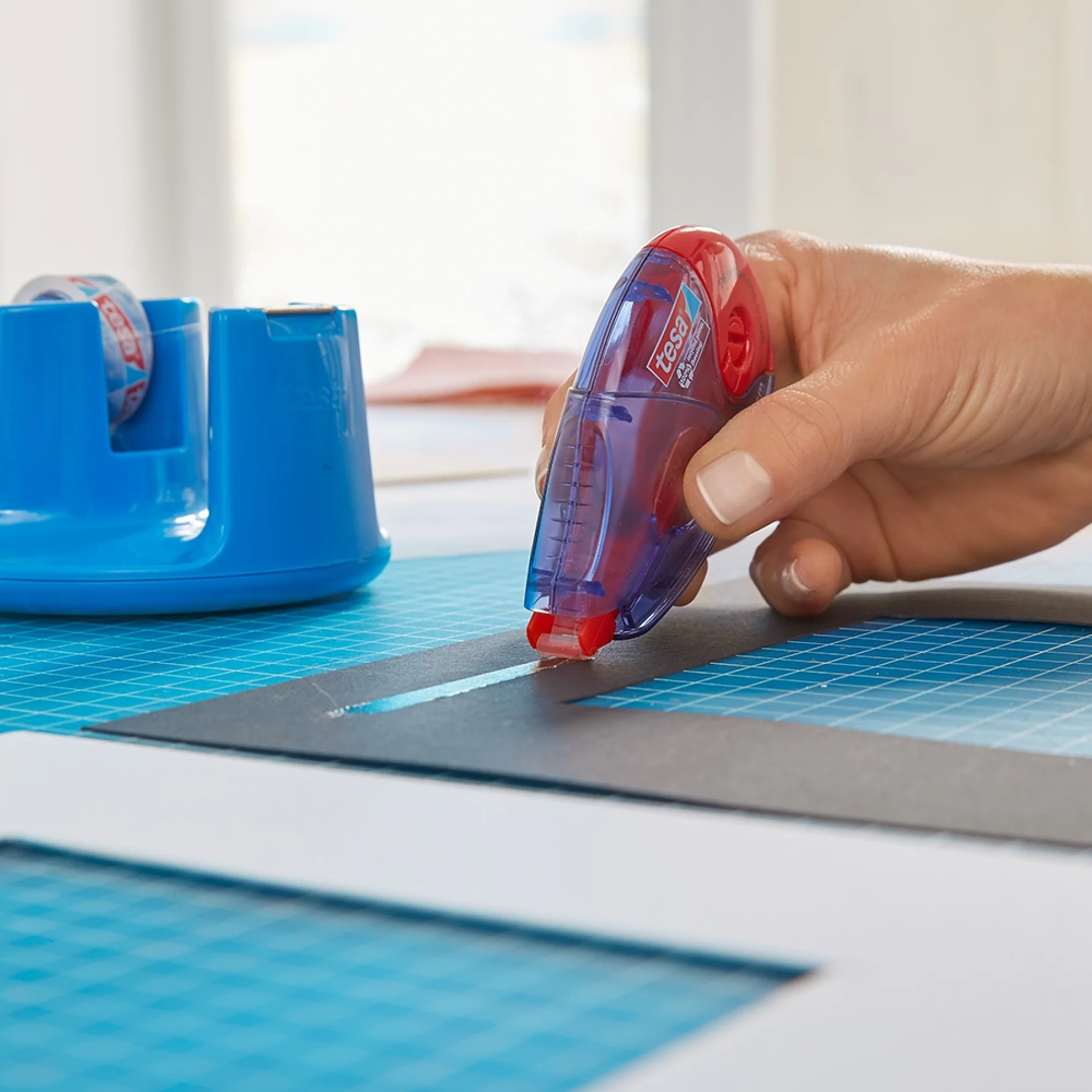 Applying glue with an adhesive roller to make a picture frame wall light.