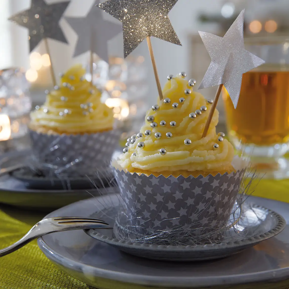 Die Cupcakes tragen ein festlich gemustertes Kleid. Passende Accessoires dazu: Deko-Sticks mit glitzernden Sternen.