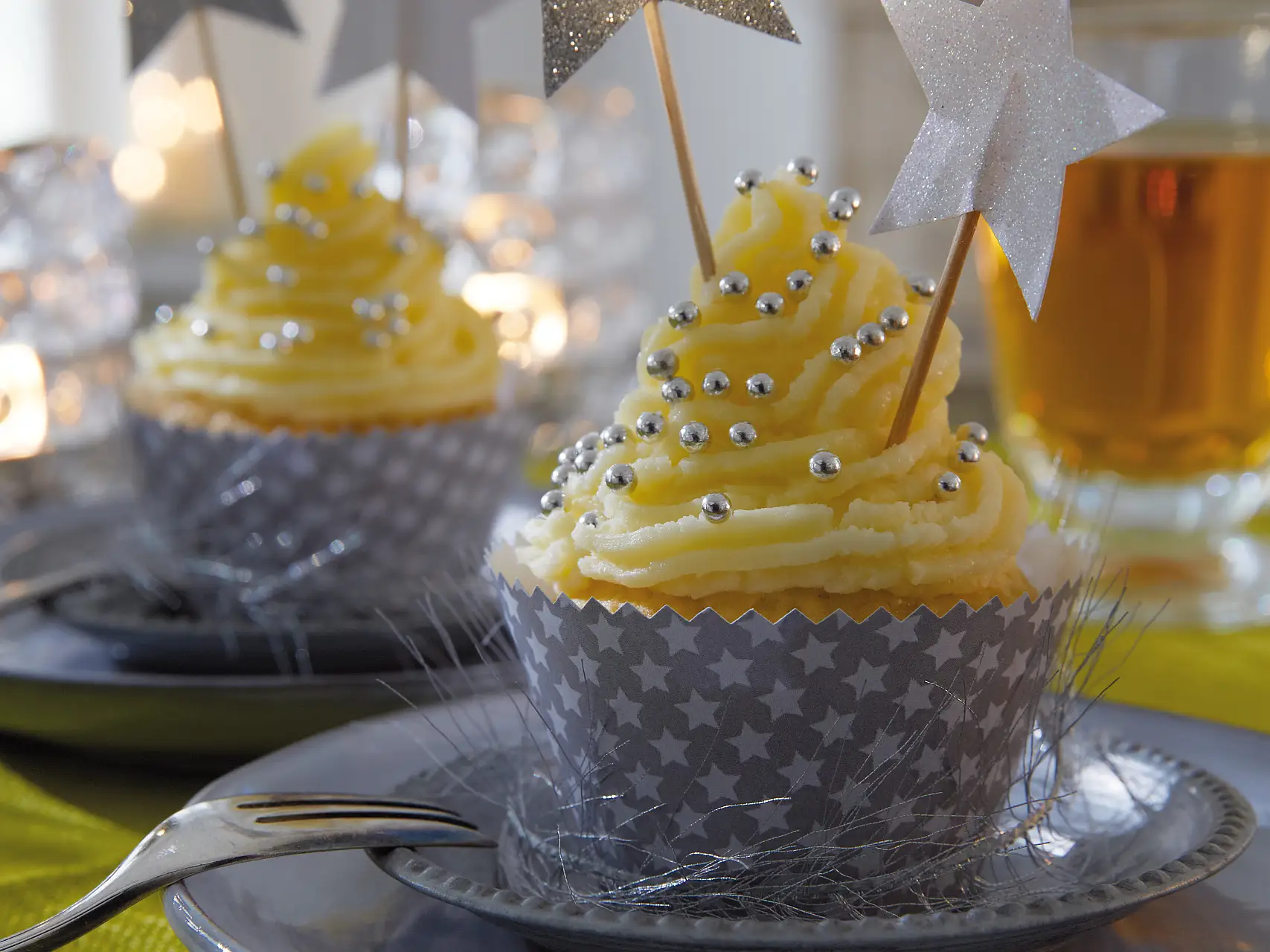 Die Cupcakes tragen ein festlich gemustertes Kleid. Passende Accessoires dazu: Deko-Sticks mit glitzernden Sternen.