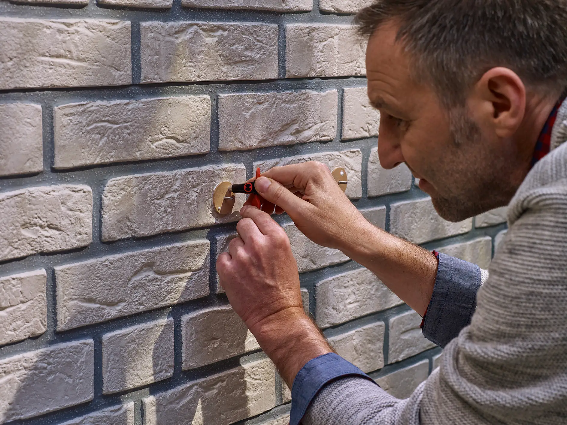 Applying the adhesive to a tesa® Adhesive Screw Round for Brick & Stone 10kg.