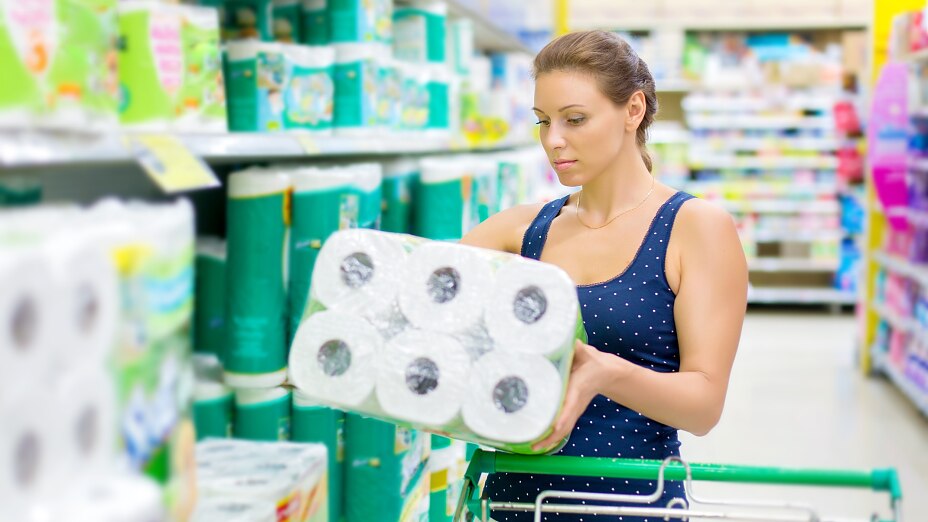 515708785 woman buys toilet paper in the supermarket