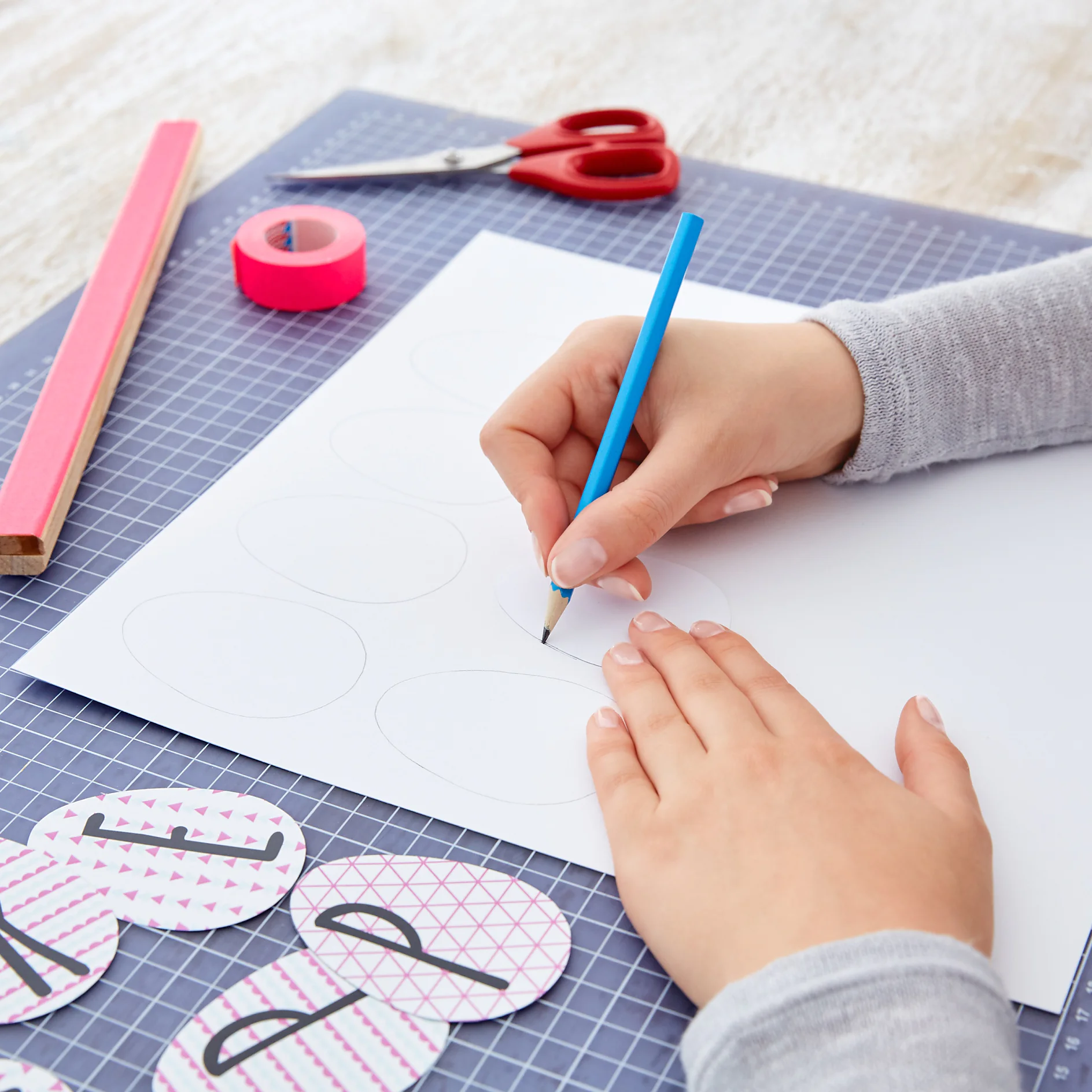 Cut out eggs from the printed cardboard. Use one as a template. Trace 11 eggs with a pencil on the white cardboard and cut them out.