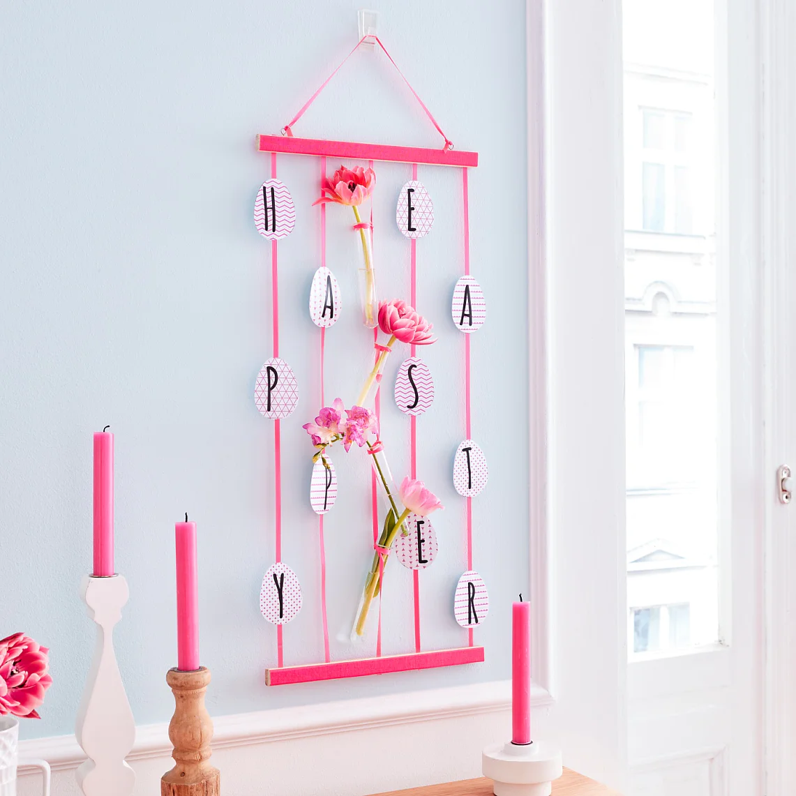 An original alternative to an Easter wallpaper that says "Happy Easter" - This Easter wall décor always looks different and fresh, when the small test tube vases are refilled.