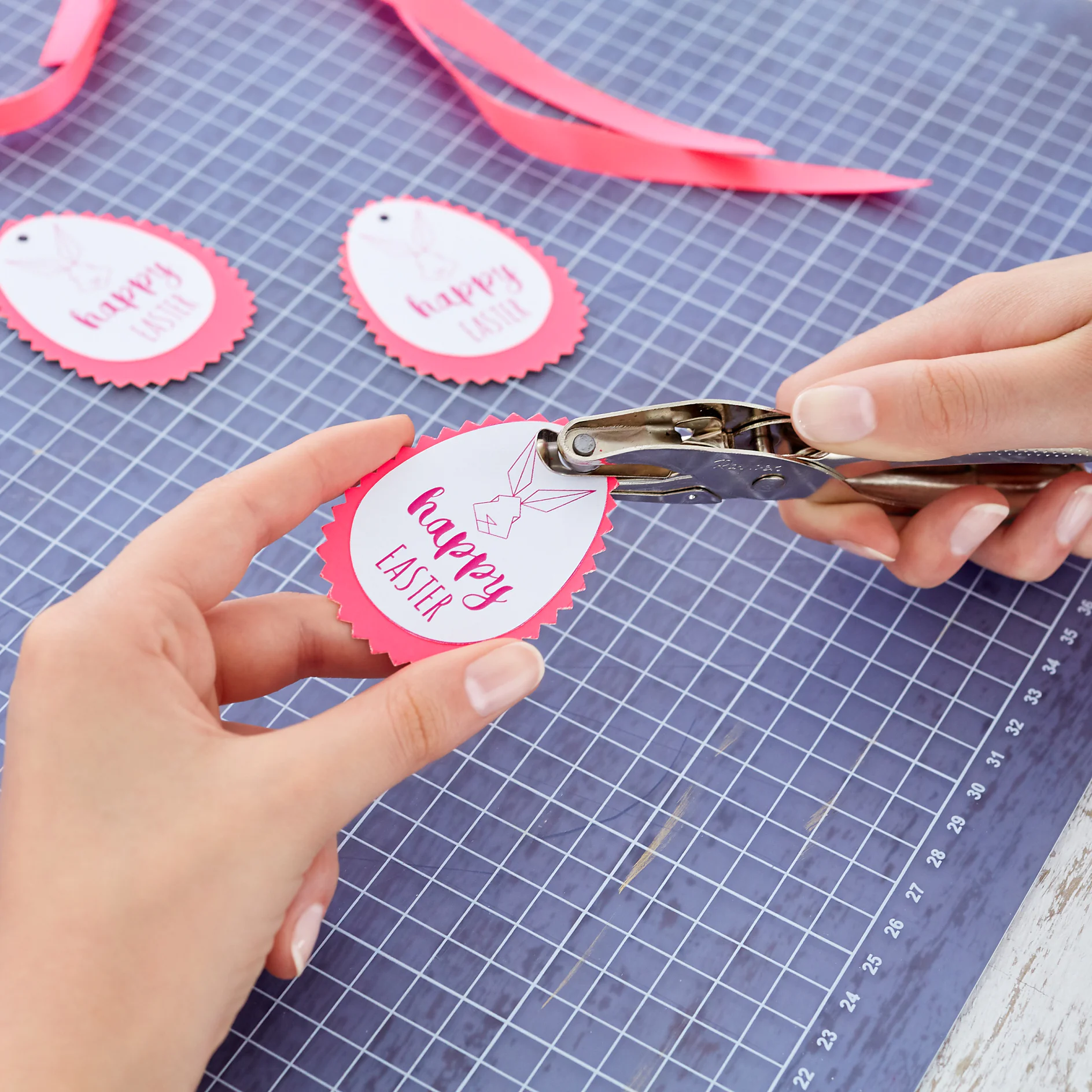 Punch a hole into the upper side of the tag.
Wrap the ribbon around the napkin and pull the ends through the hole. Arrange the napkins next to the Easter dinnerware.