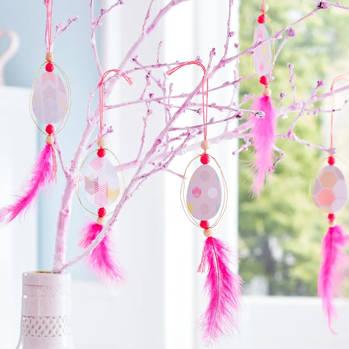 These Easter egg hangers remind us of dream catchers and look great on a simple twig - like in our Easter tree decoration -, as well as on a birch branch with soft green.