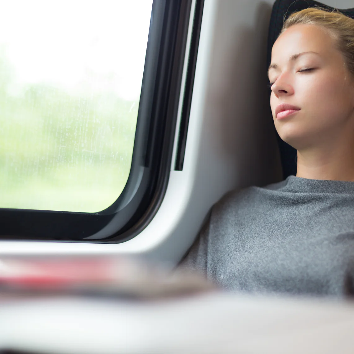 Casual lady napping while traveling by train.