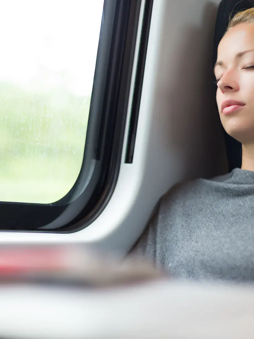 Casual lady napping while traveling by train.