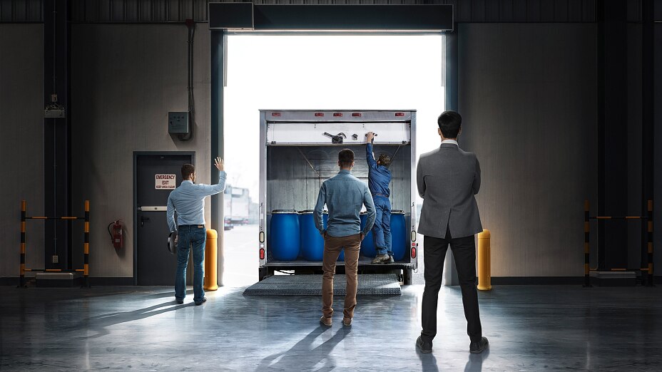 A small stack of products in boxes sitting on a manual pallet jack in a loading dock door at a distribution warehouse. A small stack of products in boxes sitting on a manual pallet jack in a loading dock door at a distribution warehouse.