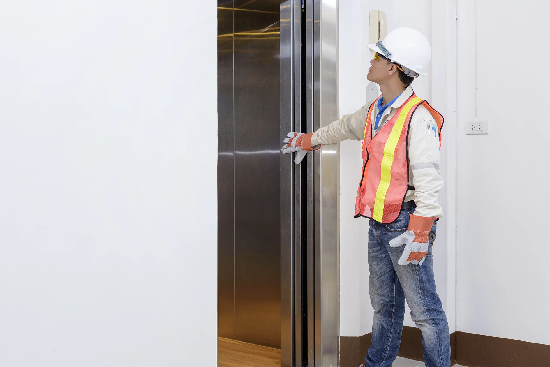 Technician investigating elevator doors Technician investigating elevator doors