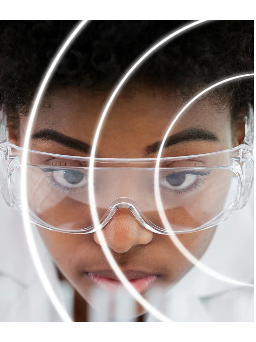 A person wearing clear safety goggles is seen in close-up, with their face partially obscured by concentric circular white lines made of tesa tape. They have short curly hair and a focused expression. The background is white, and the image has a futuristic feel. (This text has been generated by AI)