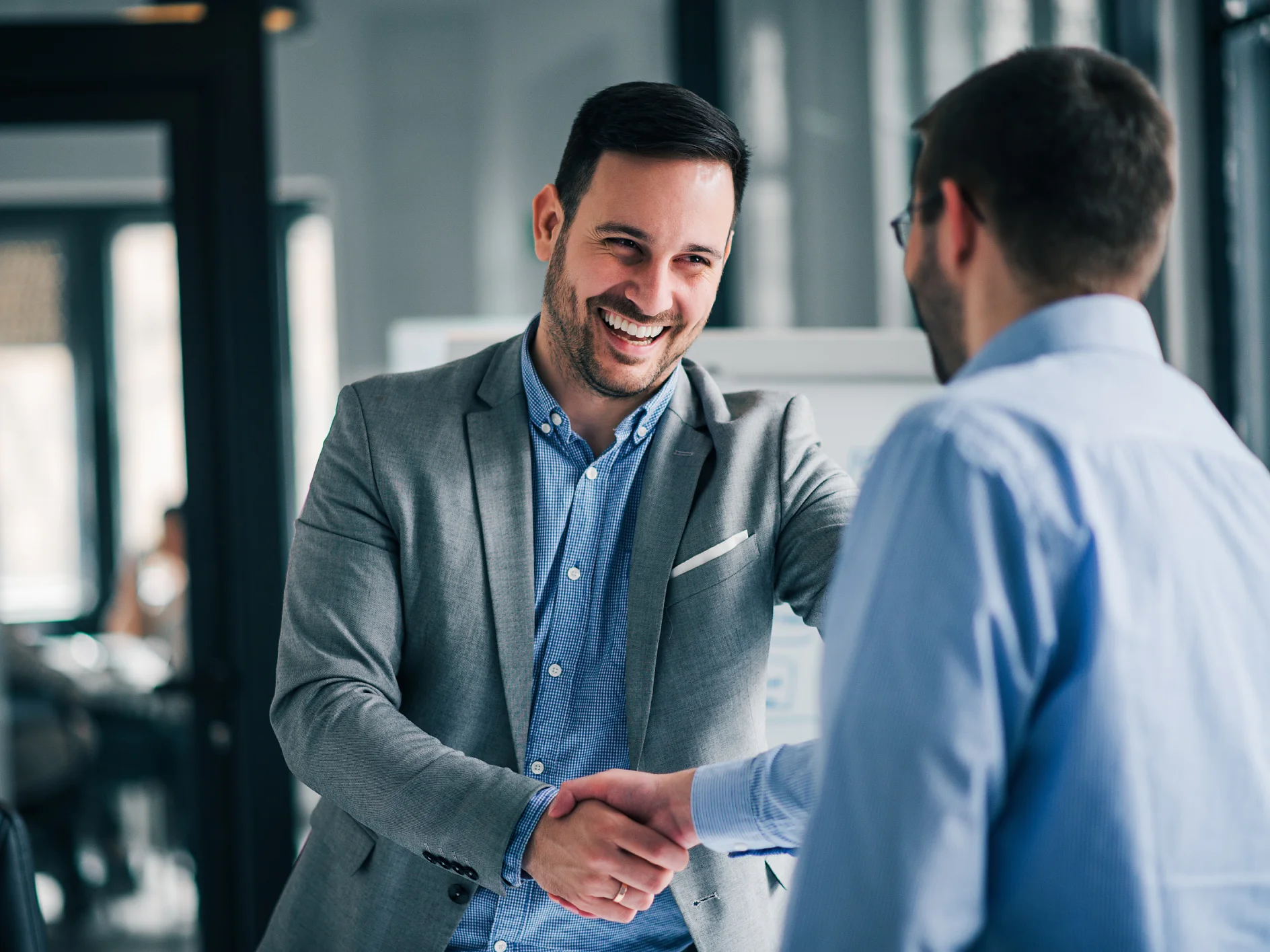 Portrait of cheerful young manager handshake with new employee. Portrait of cheerful young manager handshake with new employee.