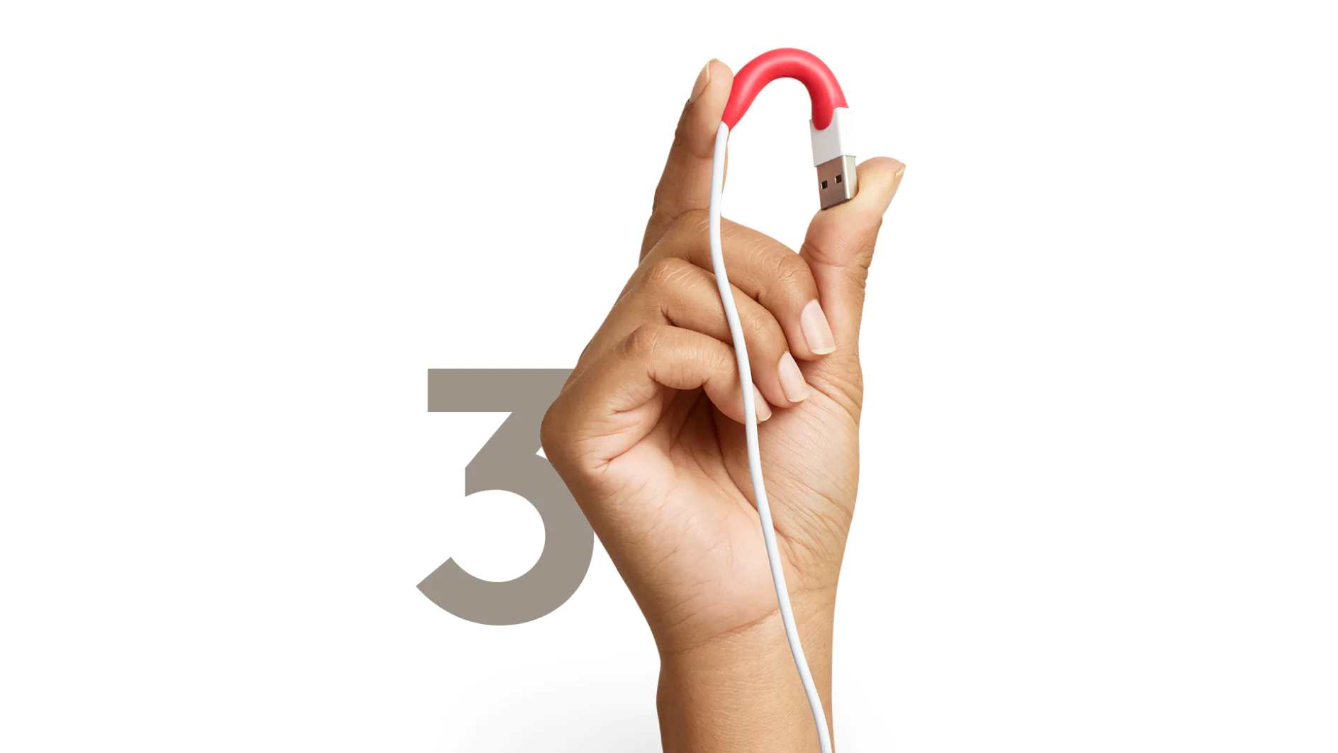 A hand is holding a USB cable with a red, rubbery bend near the connector. The cable is white, and the background features a large, partially visible number tesa in a light gray color. (This text has been generated by AI)