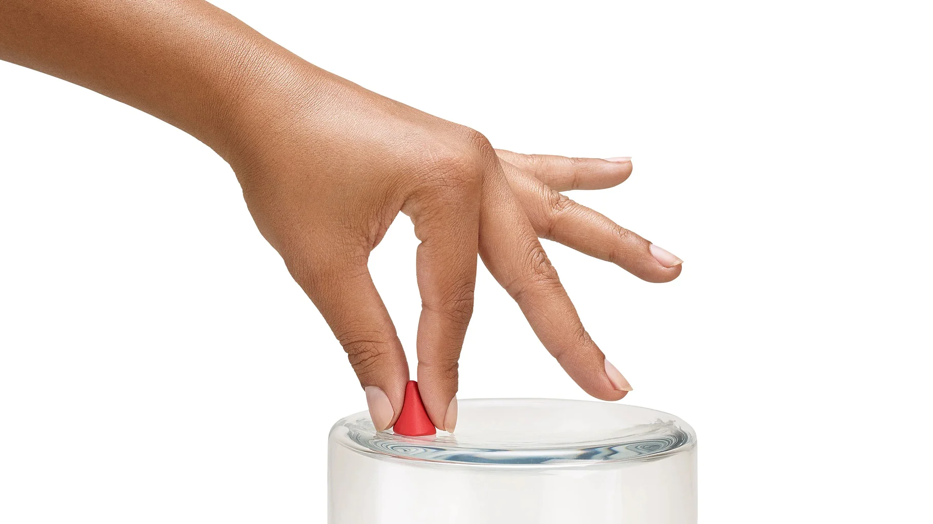 glass_mobile A hand with red nail polish on the index finger is gently stirring clear liquid in a glass. The background is plain white. (This text has been generated by AI)