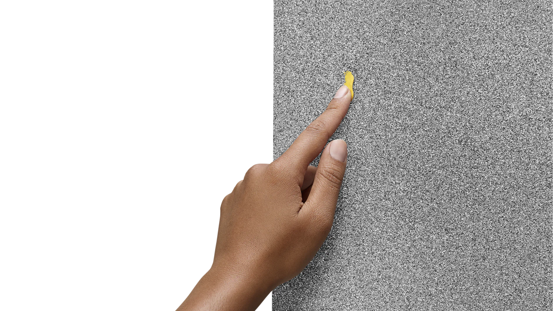 20200827_Sugru_Hygene61966 (1) A person wearing a purple sleeve is touching a large sheet of sandpaper with their index finger. The sandpaper appears gray and textured, held in place by tesa tape. (This text has been generated by AI)