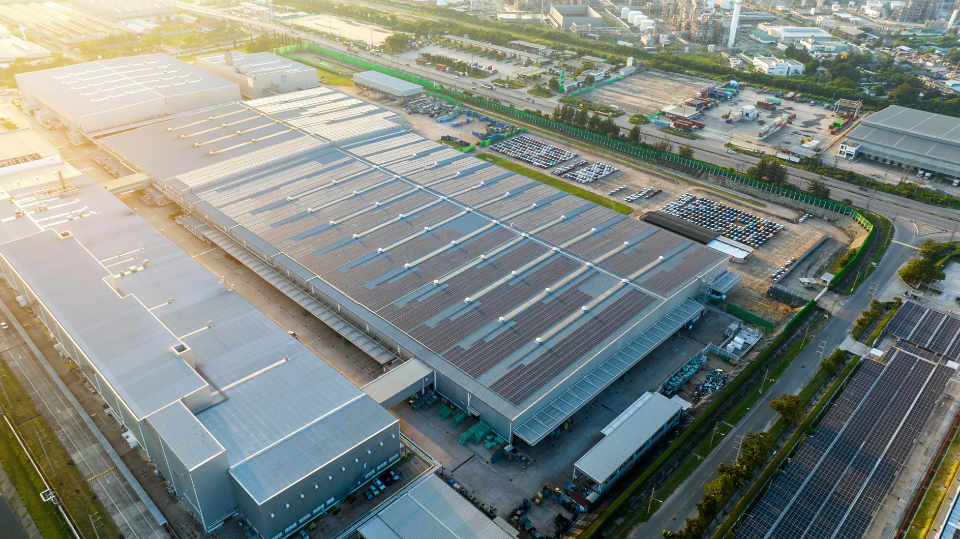 Top view Solar Panels on Warehouse Factory. Solar photo voltaic panels system power or Solar Cell on industrial building roof for producing green ecological electricity. Production of renewable energy at sunset