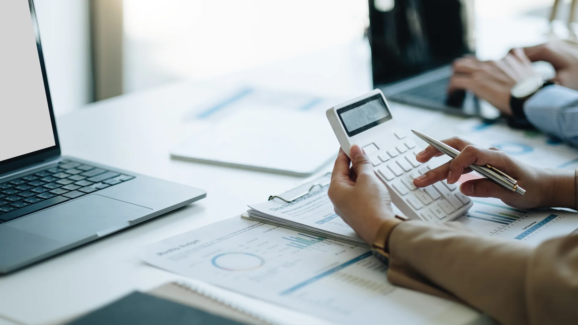 businesswoman accountant hand working on calculator to calculate financial data report, accountancy document and laptop computer at office, business concept