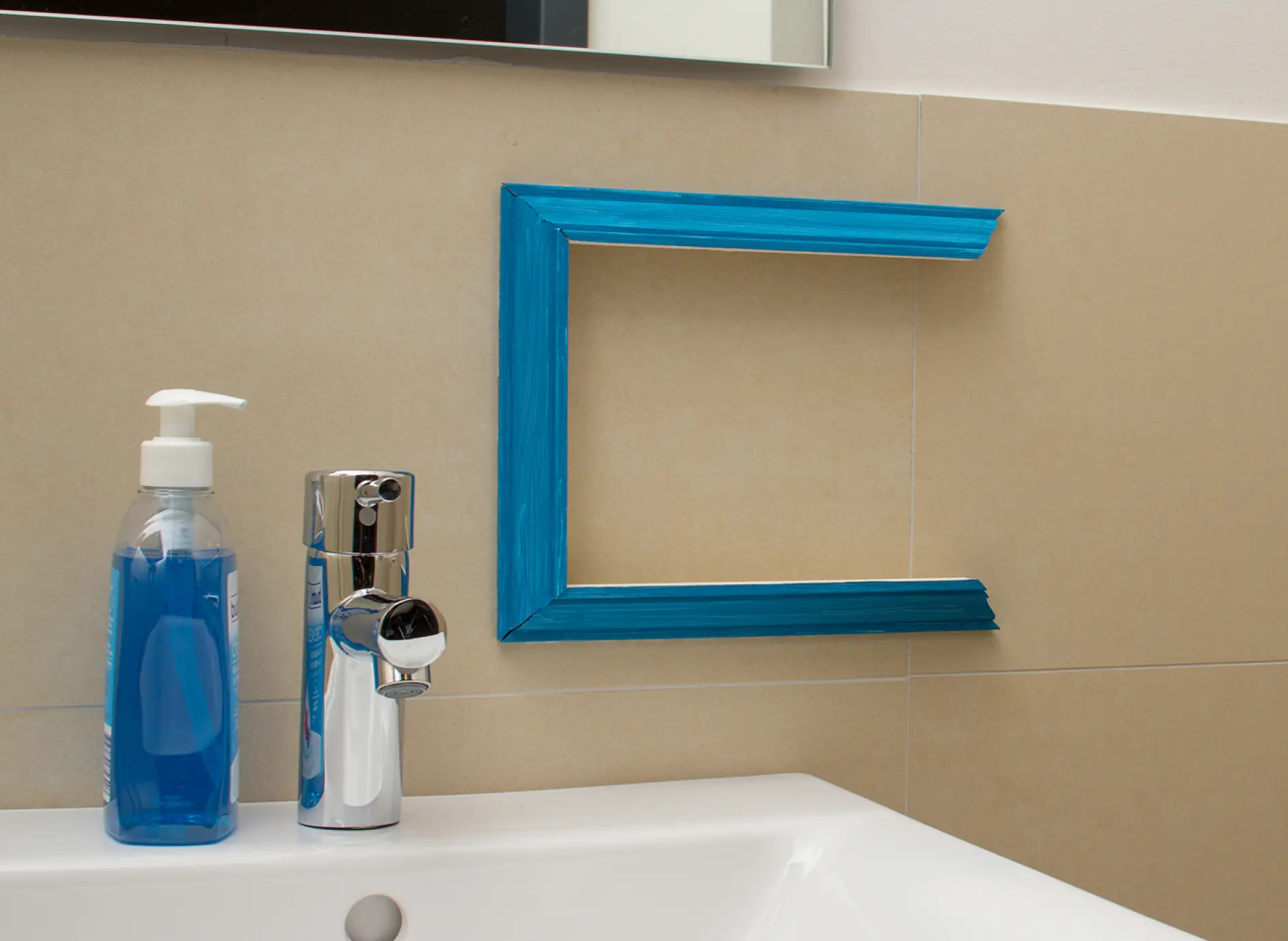 Three plaster moldings are attached with tesa Powerbond® MIRROR on the bathroom tiles