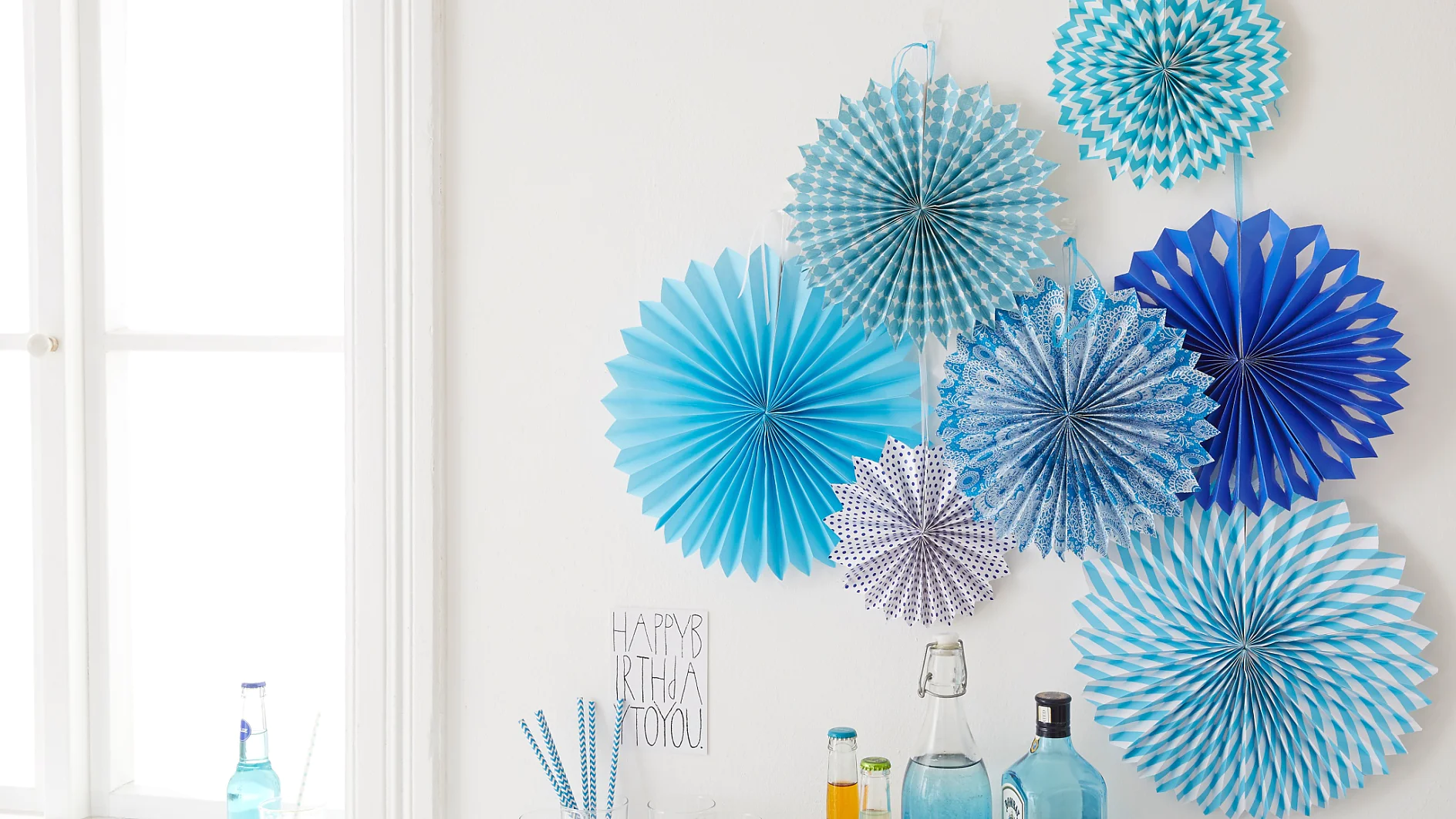 Interior decorating: The birthday party decorations "paper rosettes" are easily mounted with the picture hangers tesa Powerstrips® Transparent DECO Hooks.