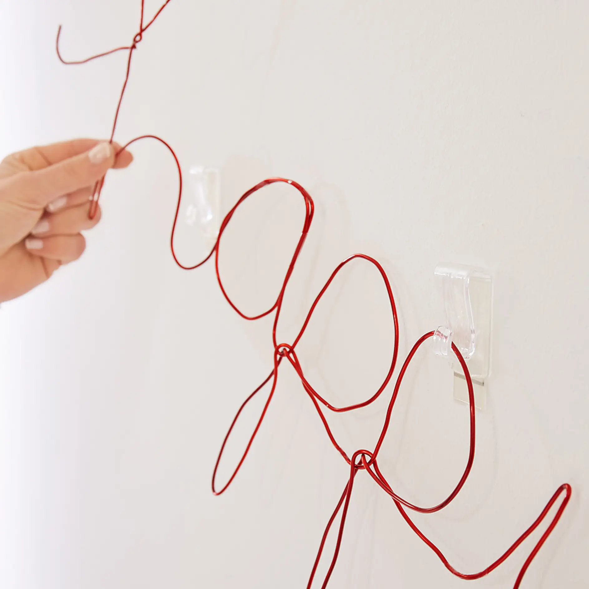 Hanging the completed wire writing using tesa® Adhesive Hook for Transparent & Glass 1kg