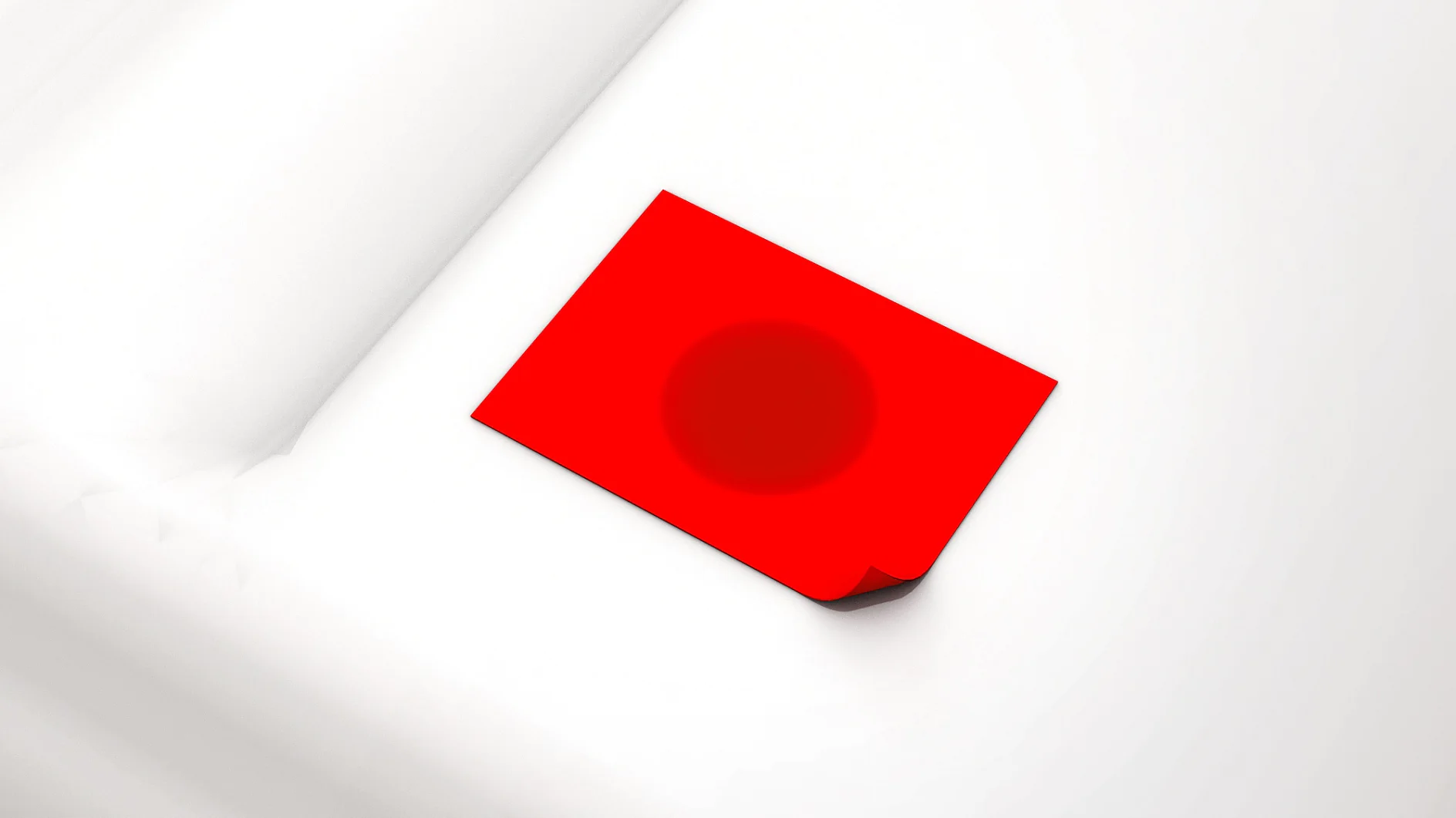 vehículos_especiales_cintas_tesa_para_camiones_caravanas_espumas A red rectangular piece of paper or card with a subtle dark circle in the center lies on a white, textured surface. The cards corner is slightly bent upwards, secured by tesa tape. (This text has been generated by AI)