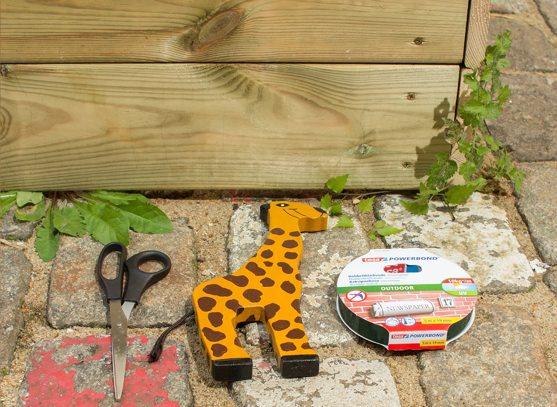 Scissors, wooden animal and tesa Powerbond® OUTDOOR adhesive tape.