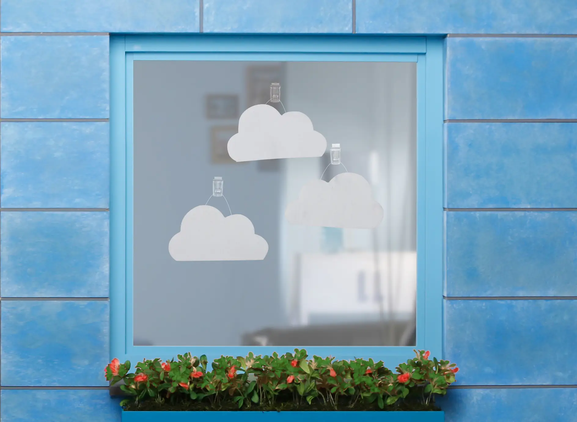 Felt clouds fixed onto a windowpane using tesa Powerstrips® Transparent DECO Hooks LARGE