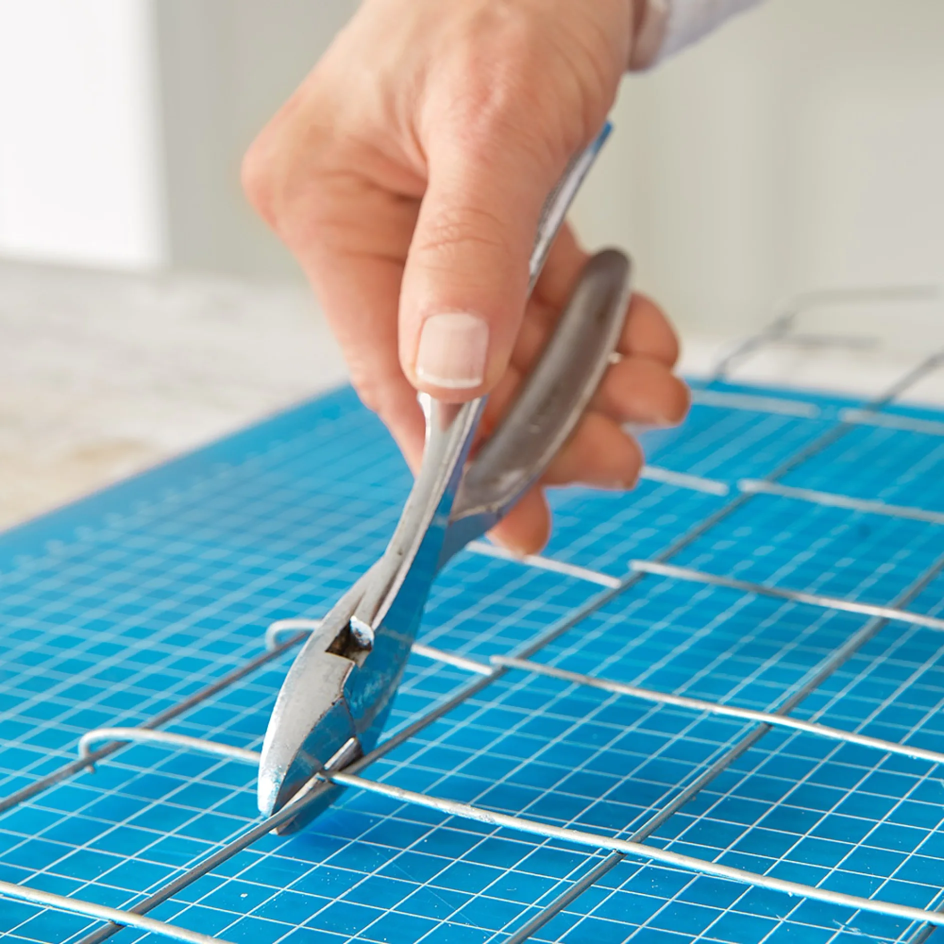 Cutting an iron mesh board office organiser to size.