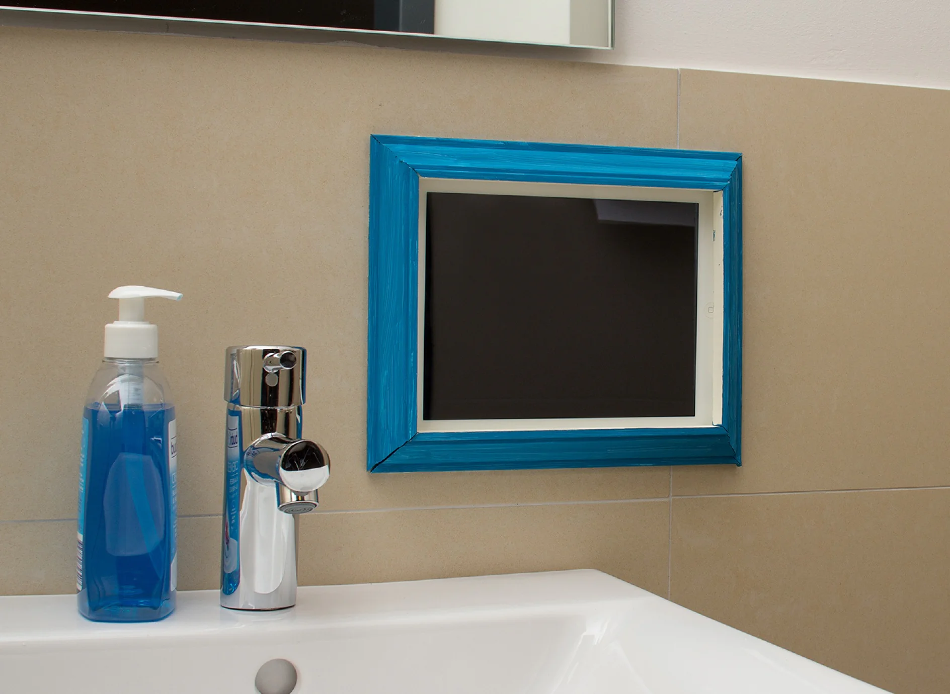 Tablet in the frame that was attached with the double-sided adhesive tape tesa Powerbond® MIRROR