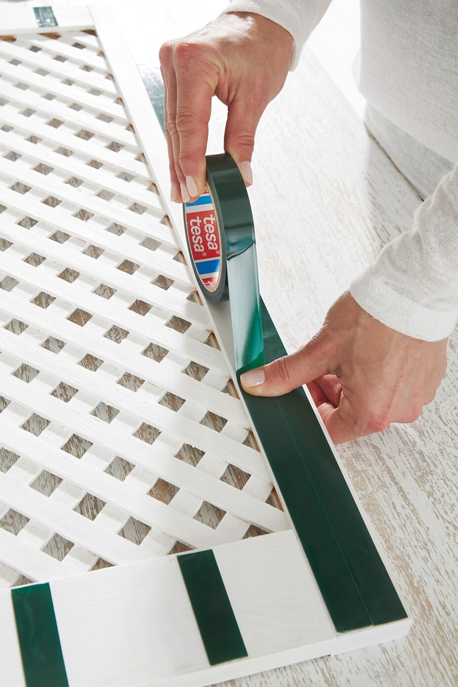 TESA_Powerbond_Handgriffe_064.jpg Thoroughly remove any dust from the reverse and apply two strips of tesa Powerbond® OUTDOOR side by side on the top and bottom of the door. Strips should be placed in a vertical direction, at a distance of about 5 cm.. Press firmly for five seconds.