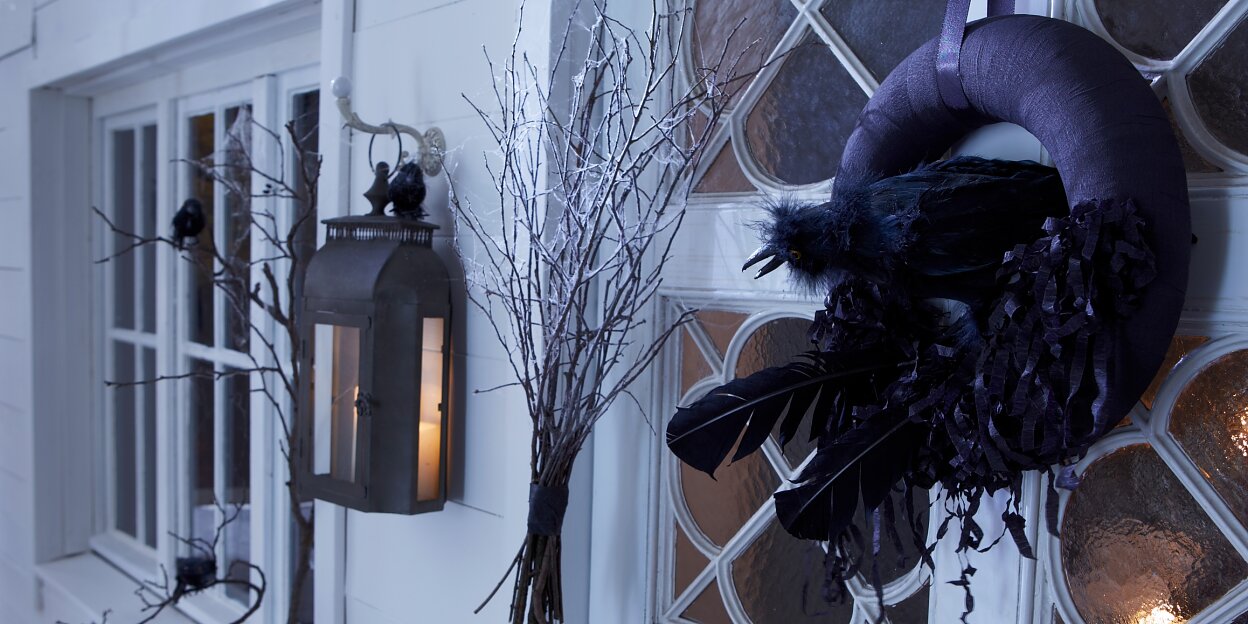 Spooky Raven Wreath Design Idea A black raven in its nest is guarding the door on Halloween.