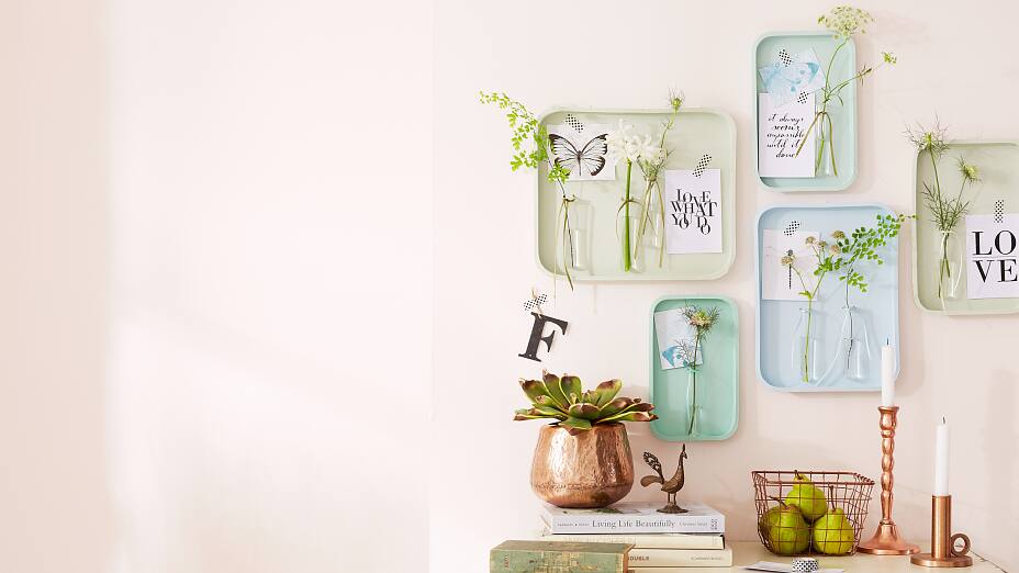 This wall decoration is made up of single trays; glass tubes are attached to them, serving as flower vases. Funny: Postcards and photos are fixed to the tray using patterned tesa® Deco Tape; it looks very decorative, but can easily be removed again.