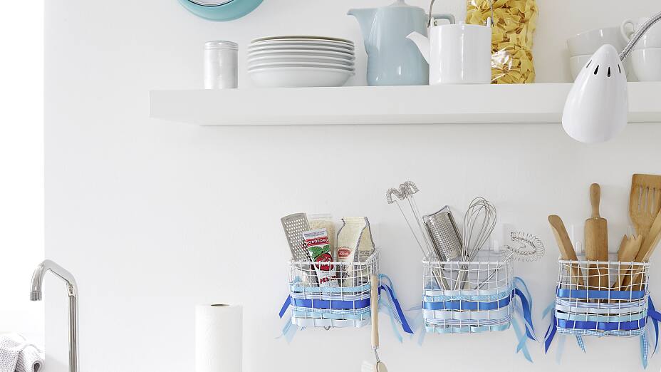 Practical kitchen storage: The metal basket organizer is a particularly beautiful kitchen accessory. The tesa Powerstrips® Hooks LARGE Classic fix this kitchen decor firmly to the wall.