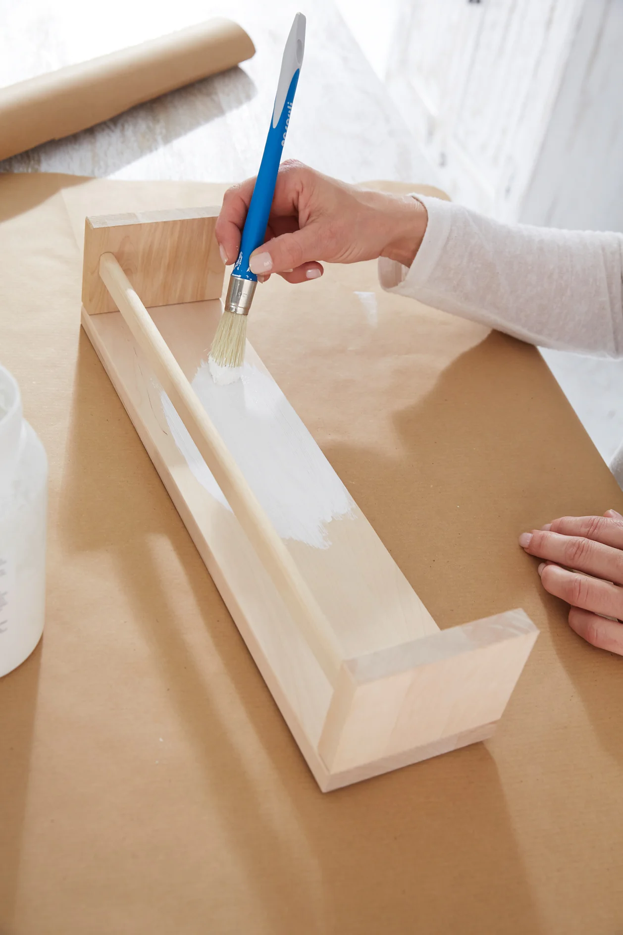 Paint the shelf with the undercoat and, once dry, the white varnish.