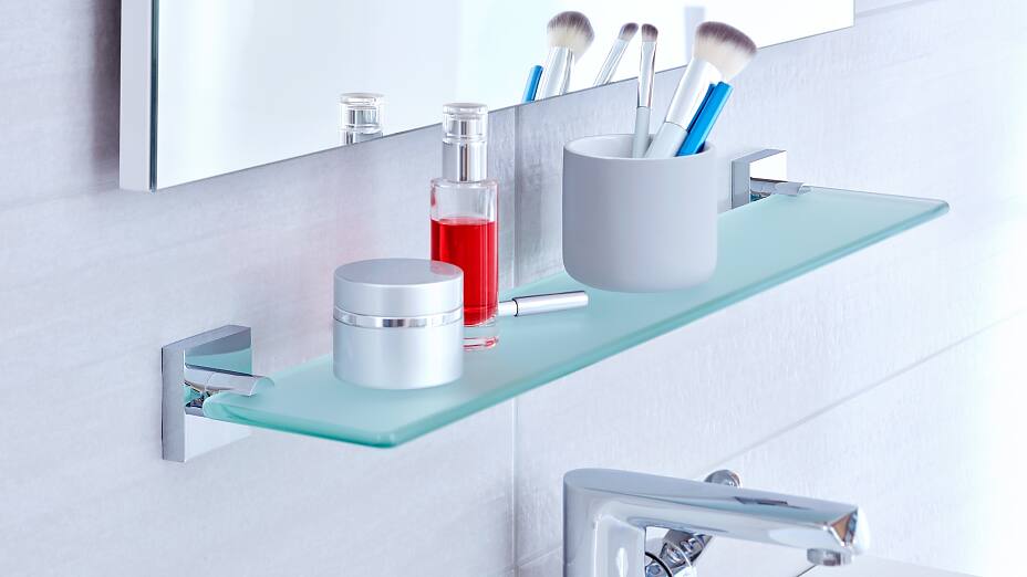 Aprovecha el espacio debajo de los espejos del baño y monta un elegante estante de cristal satinado en la pared.