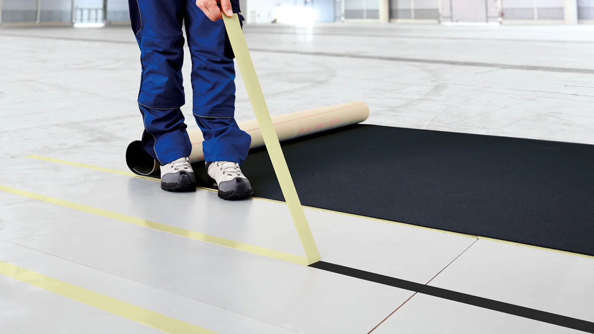 Applying tesa® 5938 Removable Black Carpet Tape at a Trade Fair