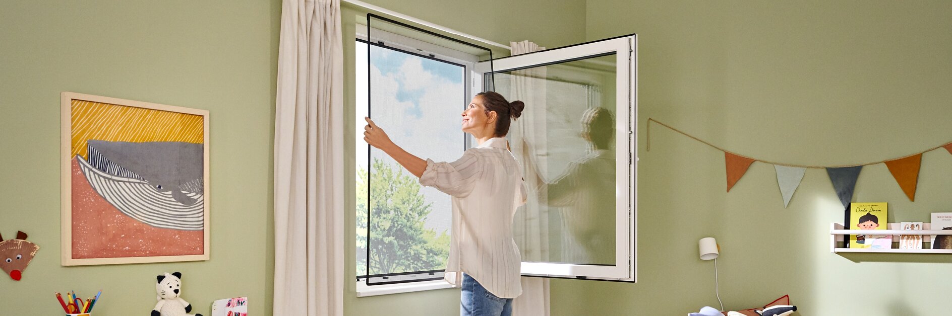 Una mujer abre una ventana en la habitación de un niño con paredes verdes. En la habitación hay una cama, juguetes y adornos de colores, como una pancarta de pared sujeta con cinta tesa y cuadros de arte. Una pequeña estantería sostiene libros y un autobús amarillo de juguete. Entra luz natural. (This text has been generated by AI)