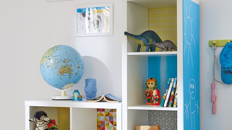 TESA_Powerbond_35920q.jpg Here's an idea that kids will love. Each shelf has its own background, using decorative paper, stuck with tesa® Spray Glue PERMANENT, and on the side of the unit, there's a big blackboard so they're free to write or paint.