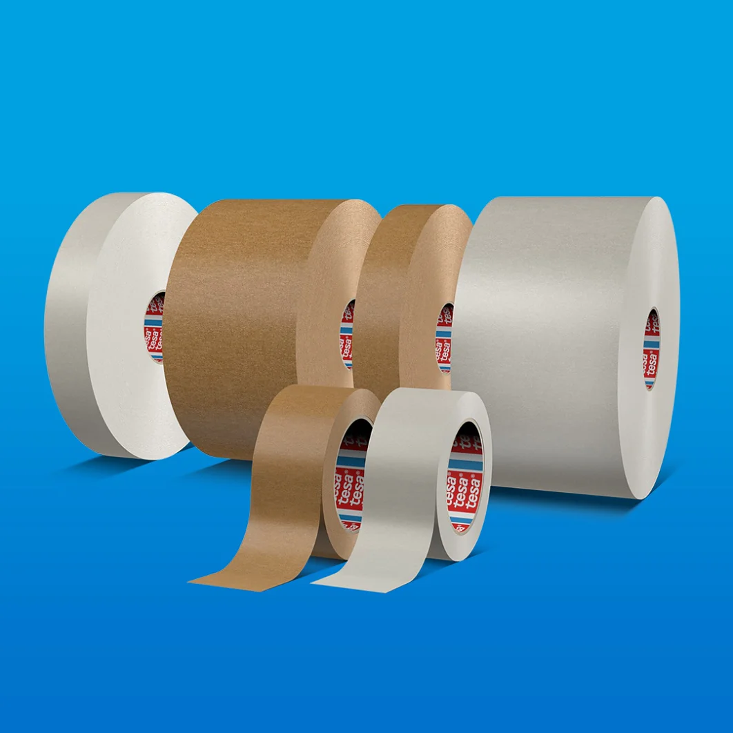 Se muestran seis rollos de cinta adhesiva tesa sobre un fondo azul. Los rollos varían en tamaño y color, incluidos tonos blancos, marrones y grises. Están dispuestos en dos filas, con tres en la parte posterior y tres en la parte frontal. (This text has been generated by AI)