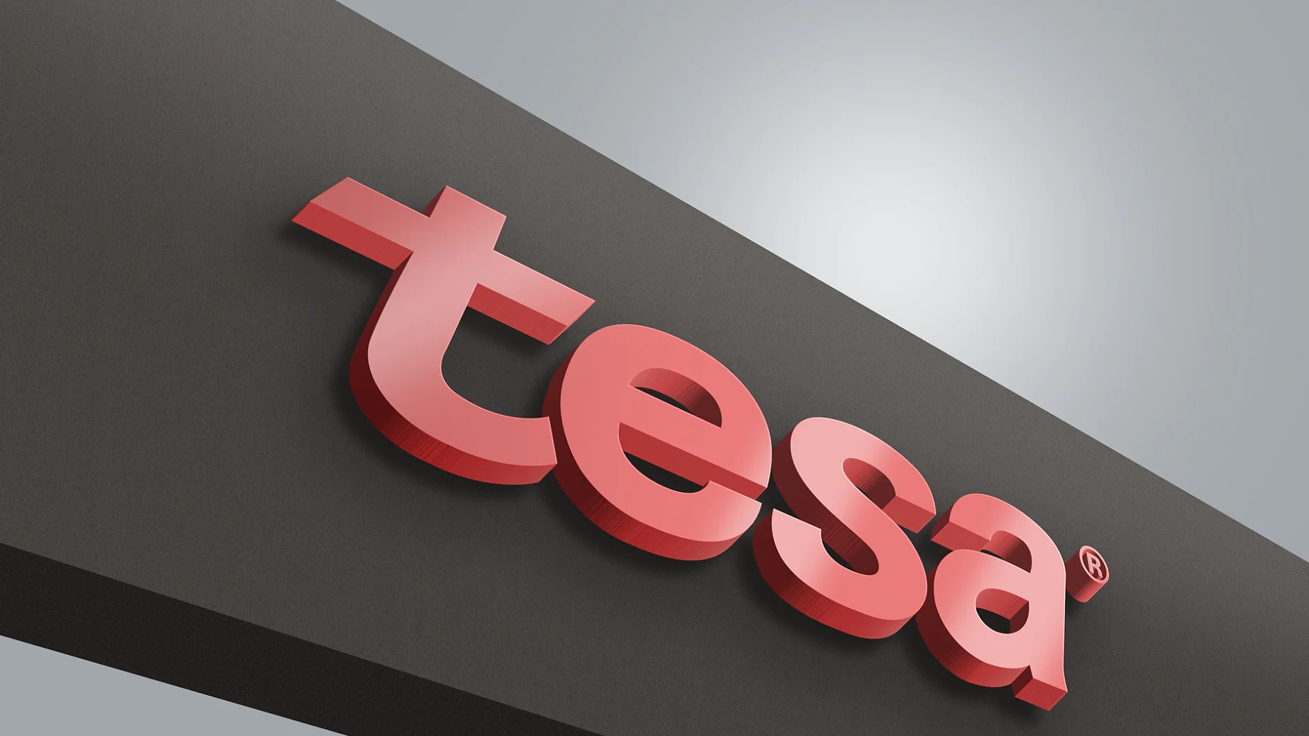 La imagen muestra un logotipo rojo en 3D de la palabra tesa tape sobre un fondo negro. Las letras están en negrita y parecen estar ligeramente elevadas, proyectando una sombra. El fondo tiene un efecto de degradado, que pasa de gris a blanco en el centro. (This text has been generated by AI)